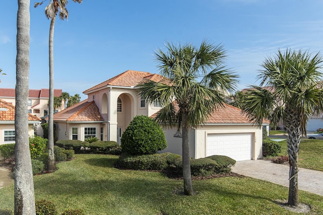 mediterranean / spanish house featuring a front yard and a garage