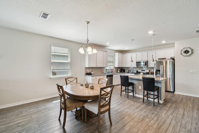 182 Myrtle Oak Ct, Saint Augustine, FL 32092 - dining room featuring light wood-style flooring, a textured ceiling, baseboards, a chandelier, and recessed lighting
