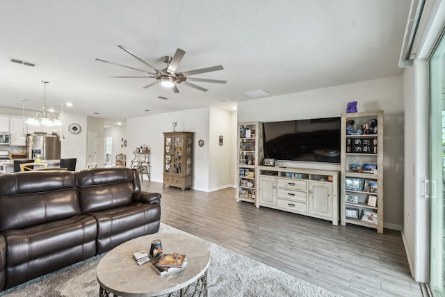 182 Myrtle Oak Ct, Saint Augustine, FL 32092 - living room featuring a ceiling fan, wood finished floors, baseboards, a chandelier, and a textured ceiling