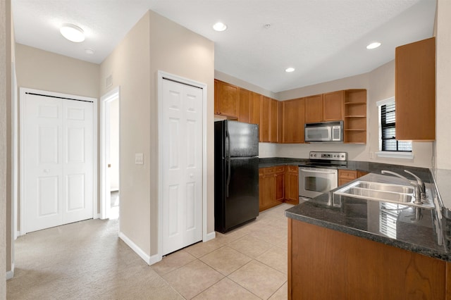 kitchen with sink, light tile patterned flooring, a textured ceiling, and appliances with stainless steel finishes