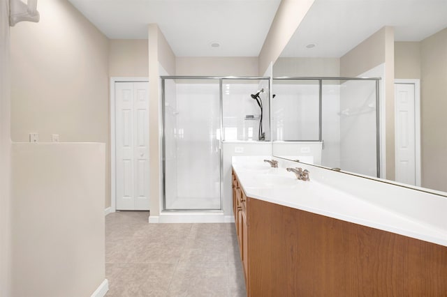 bathroom with tile patterned floors, vanity, and a shower with shower door