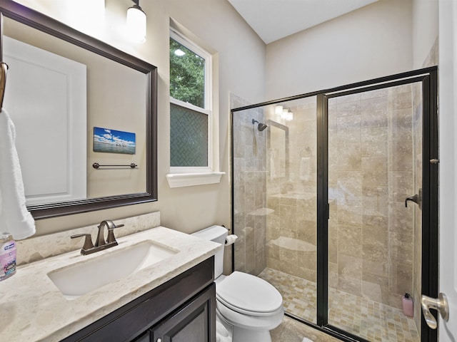 bathroom featuring a shower with door, vanity, and toilet