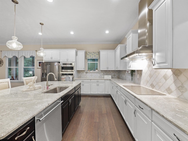 kitchen with backsplash, stainless steel appliances, sink, wall chimney range hood, and white cabinetry