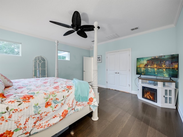 bedroom featuring a closet, ceiling fan, crown molding, and dark hardwood / wood-style floors