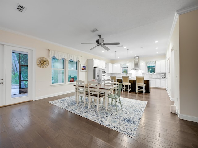 dining space featuring ceiling fan, dark wood-type flooring, and ornamental molding