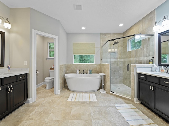 full bathroom featuring toilet, vanity, and shower with separate bathtub