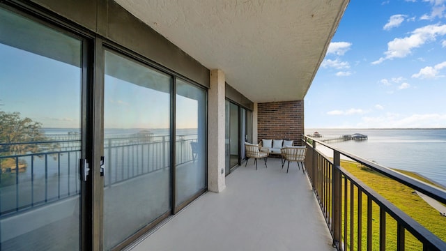 balcony featuring outdoor lounge area and a water view