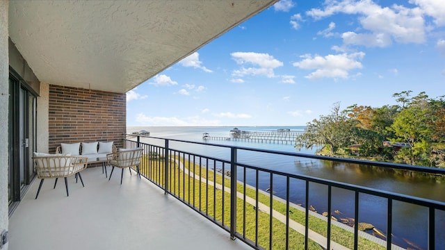 balcony featuring outdoor lounge area and a water view