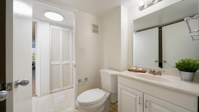 bathroom with tile patterned flooring, vanity, and toilet