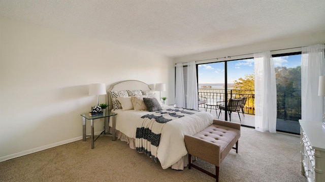 carpeted bedroom featuring access to exterior and a textured ceiling