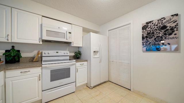 kitchen with a textured ceiling, white cabinetry, light tile patterned floors, and white appliances