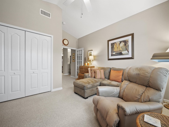 carpeted living room with ceiling fan and high vaulted ceiling