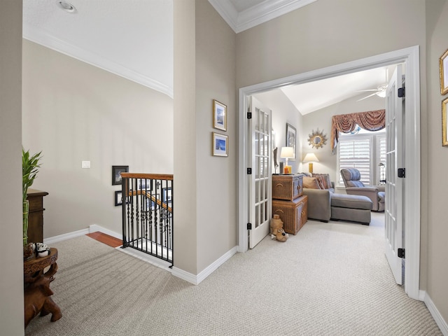 corridor featuring light colored carpet, crown molding, and lofted ceiling