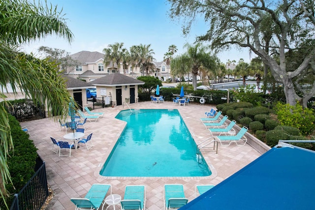 view of pool featuring an outbuilding and a patio