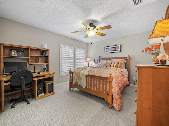 carpeted bedroom with ceiling fan and a textured ceiling