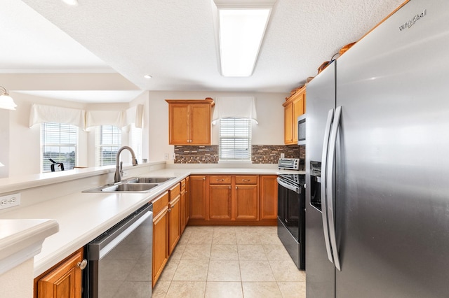 kitchen with kitchen peninsula, appliances with stainless steel finishes, backsplash, and sink