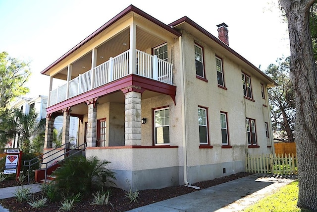 78 Riberia St, Saint Augustine, FL 32084 - view of property exterior featuring a balcony, crawl space, a chimney, covered porch, and stucco siding