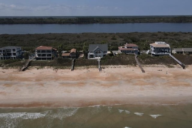 drone / aerial view with a water view and a beach view