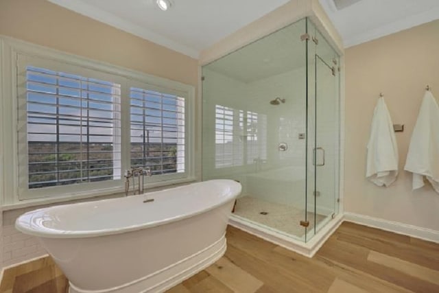 bathroom with hardwood / wood-style floors, independent shower and bath, and crown molding