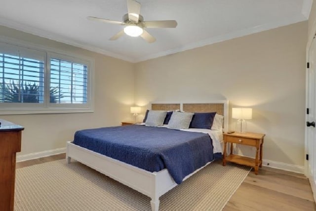 bedroom featuring ceiling fan, light hardwood / wood-style flooring, and crown molding