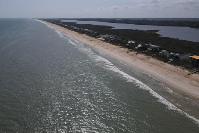 drone / aerial view featuring a water view and a beach view