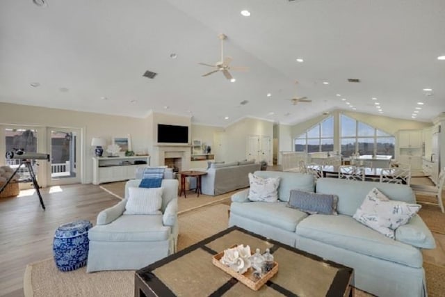 living room featuring ceiling fan, light hardwood / wood-style flooring, and vaulted ceiling