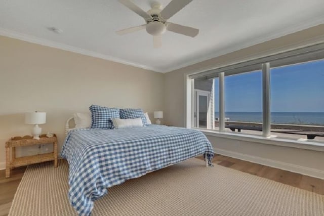 bedroom featuring a water view, crown molding, ceiling fan, and hardwood / wood-style flooring