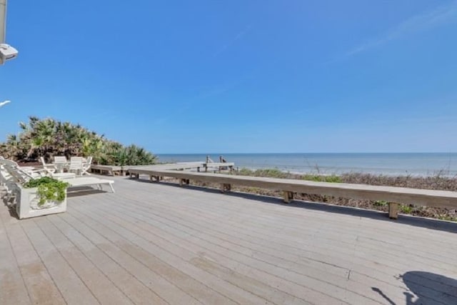 wooden deck featuring a water view and a beach view