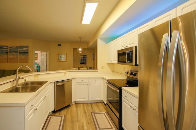 35103 Harbour Vista Cir, Saint Augustine, FL 32080 - kitchen with a peninsula, light countertops, a sink, light wood-style flooring, and stainless steel appliances
