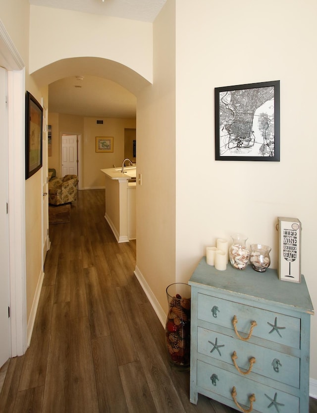 35103 Harbour Vista Cir, Saint Augustine, FL 32080 - hallway featuring arched walkways, baseboards, and dark wood-type flooring