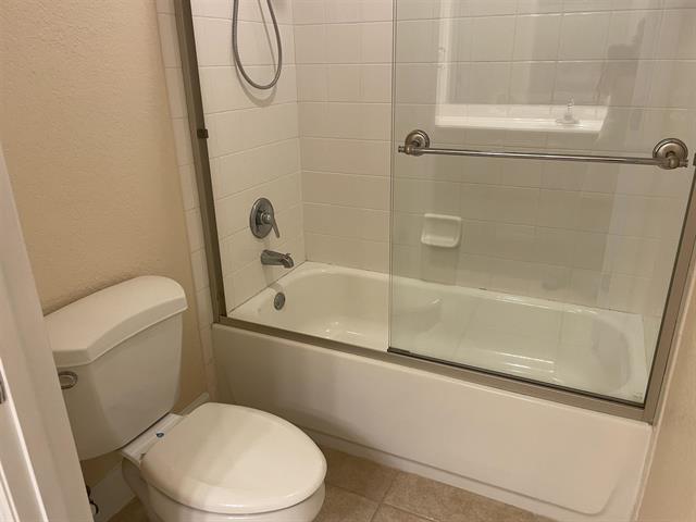 623 Shores Blvd, Saint Augustine Shores, FL 32086 - bathroom featuring combined bath / shower with glass door, tile patterned floors, and toilet