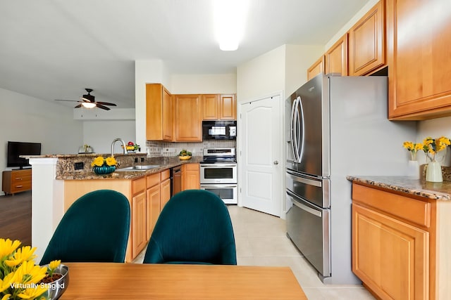623 Shores Blvd, Saint Augustine Shores, FL 32086 - kitchen with appliances with stainless steel finishes, a sink, tasteful backsplash, a ceiling fan, and a peninsula