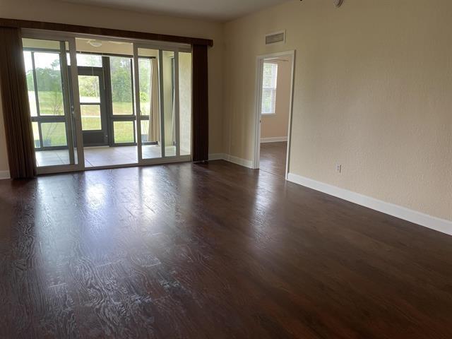 623 Shores Blvd, Saint Augustine Shores, FL 32086 - empty room with a healthy amount of sunlight and dark hardwood / wood-style flooring