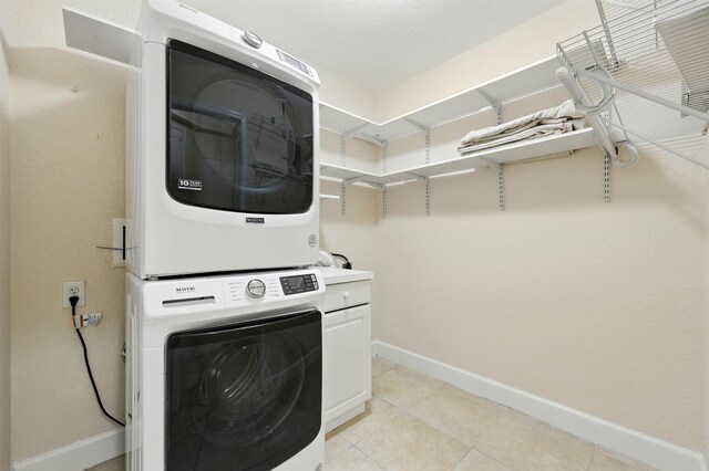 623 Shores Blvd, Saint Augustine Shores, FL 32086 - laundry area with stacked washer / dryer, baseboards, cabinet space, and light tile patterned floors