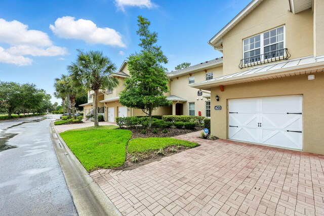 623 Shores Blvd, Saint Augustine Shores, FL 32086 - multi unit property with stucco siding, decorative driveway, a standing seam roof, a garage, and metal roof