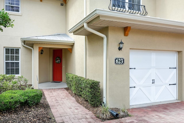 623 Shores Blvd, Saint Augustine Shores, FL 32086 - doorway to property featuring stucco siding, a standing seam roof, a garage, and metal roof