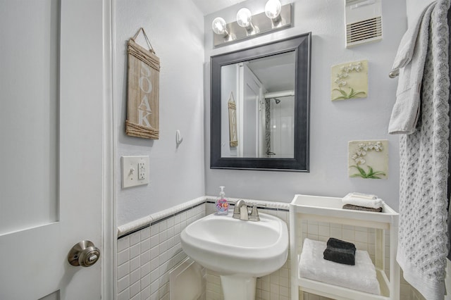 bathroom with tile walls and sink