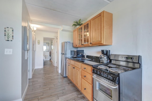 kitchen featuring dark stone countertops, sink, and appliances with stainless steel finishes