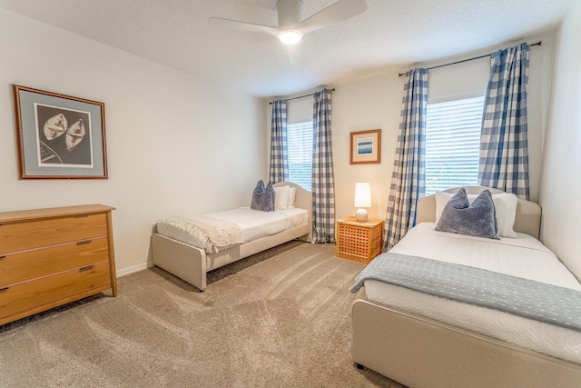 bedroom with light carpet, a textured ceiling, and a ceiling fan