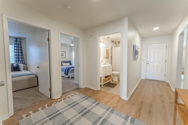 hall with baseboards and light wood-style floors