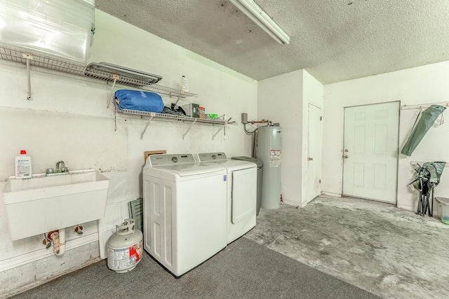 clothes washing area with water heater, laundry area, independent washer and dryer, a textured ceiling, and a sink