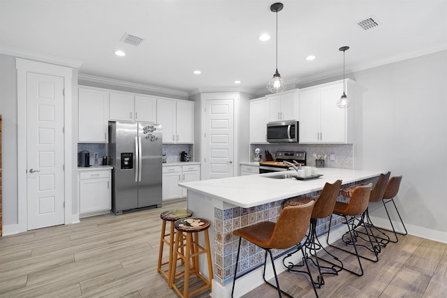 5450 A1A, Saint Augustine, FL 32080 - kitchen with stainless steel appliances, ornamental molding, a kitchen breakfast bar, a peninsula, and white cabinetry