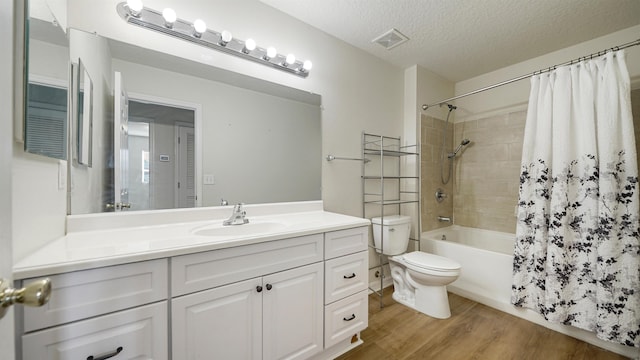 full bathroom featuring hardwood / wood-style flooring, vanity, toilet, shower / bath combo, and a textured ceiling