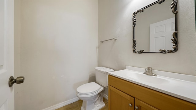 bathroom featuring vanity, hardwood / wood-style floors, and toilet