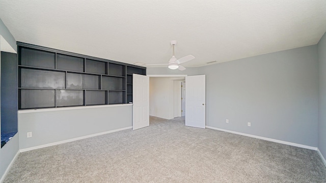 carpeted spare room with a textured ceiling and ceiling fan