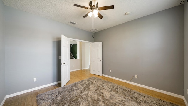 bedroom featuring hardwood / wood-style flooring, ceiling fan, and a textured ceiling