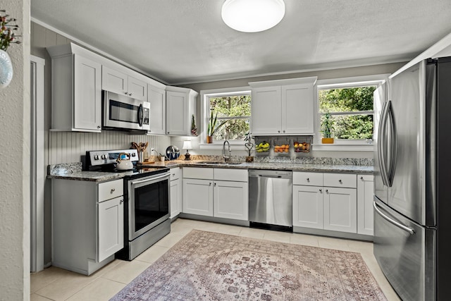 215 Jasmine Rd, Saint Augustine, FL 32086 - kitchen featuring stainless steel appliances, a sink, plenty of natural light, light tile patterned floors, and a textured ceiling