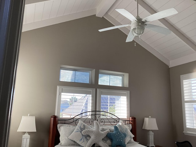 bedroom featuring vaulted ceiling with beams, ceiling fan, and multiple windows