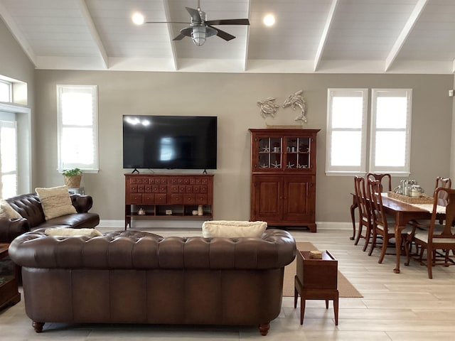 living room with ceiling fan, vaulted ceiling, and light wood-type flooring