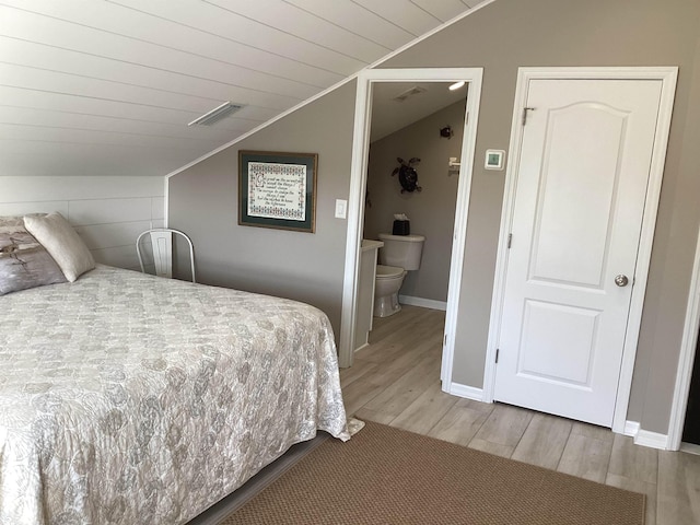 bedroom featuring ensuite bath, wood ceiling, lofted ceiling, and hardwood / wood-style flooring